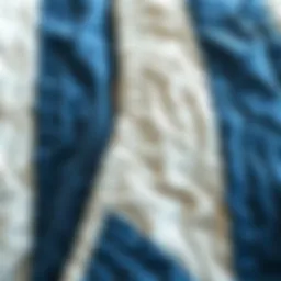 A close-up view of a blue and white striped quilt showcasing intricate stitching.